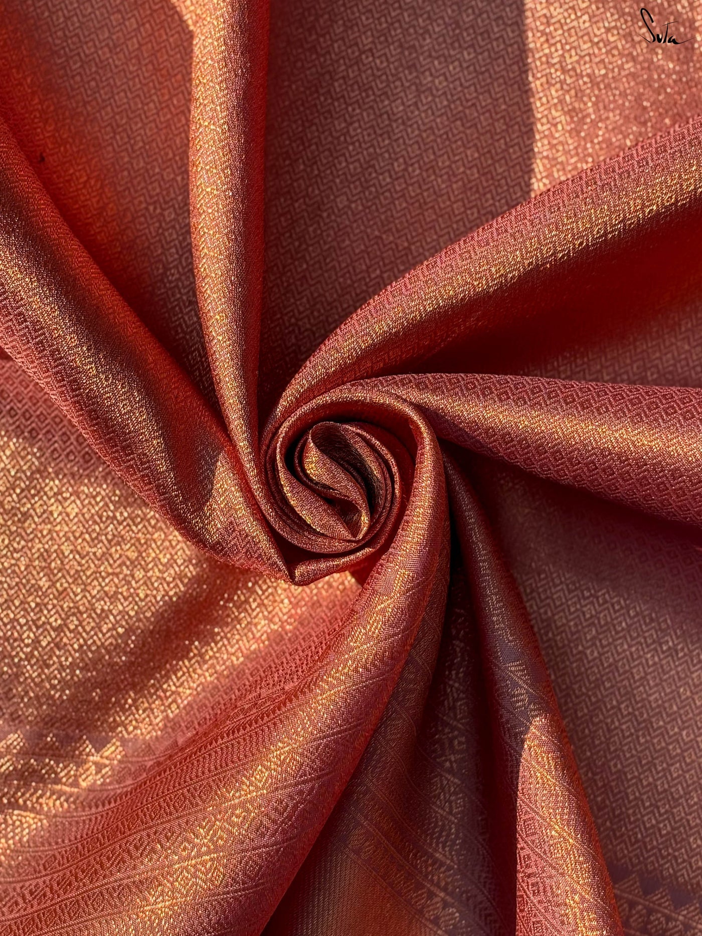Close-up of a folded piece of red fabric with gold patterns