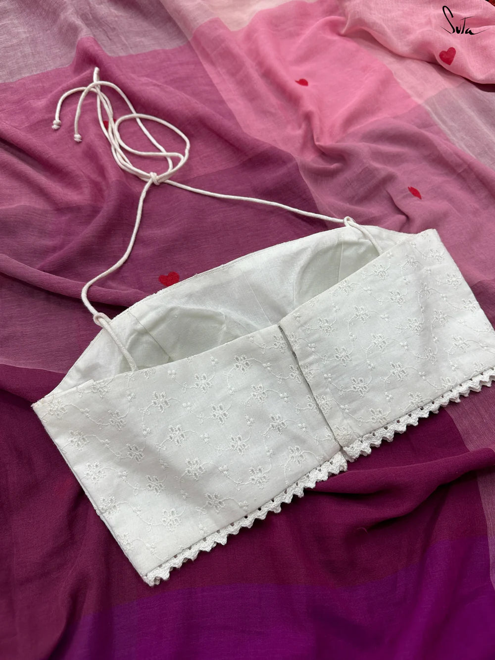 White blouse on a pink and purple fabric background