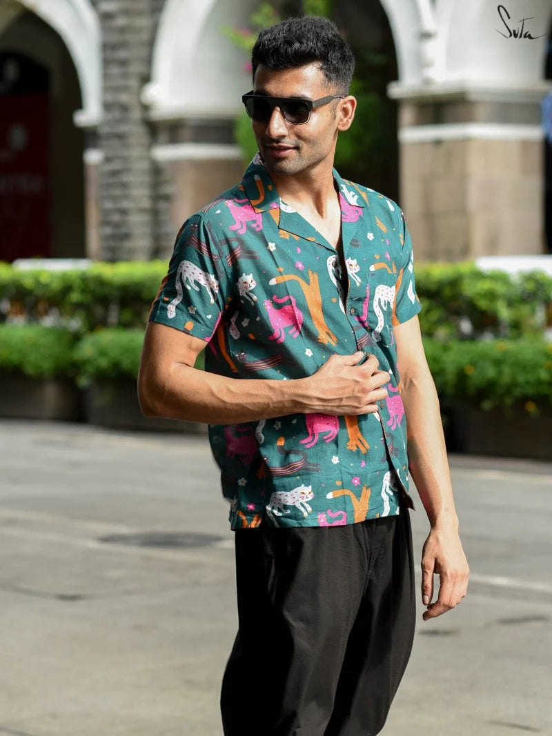 Man wearing a teal colorful patterned shirt on a street background