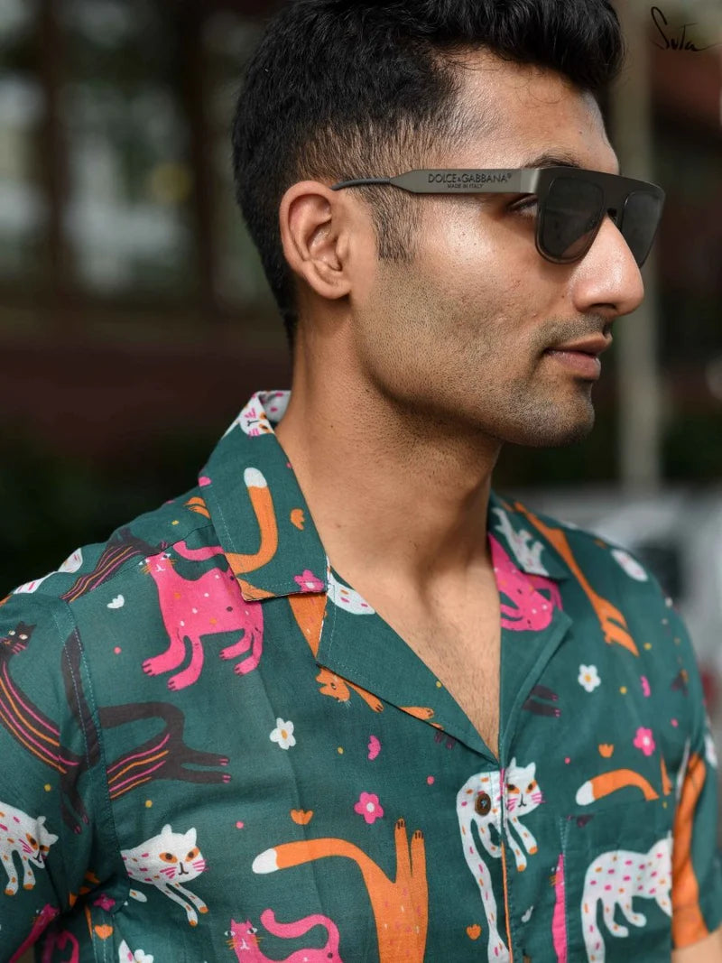Man wearing a colorful patterned shirt with sunglasses, blurred background
