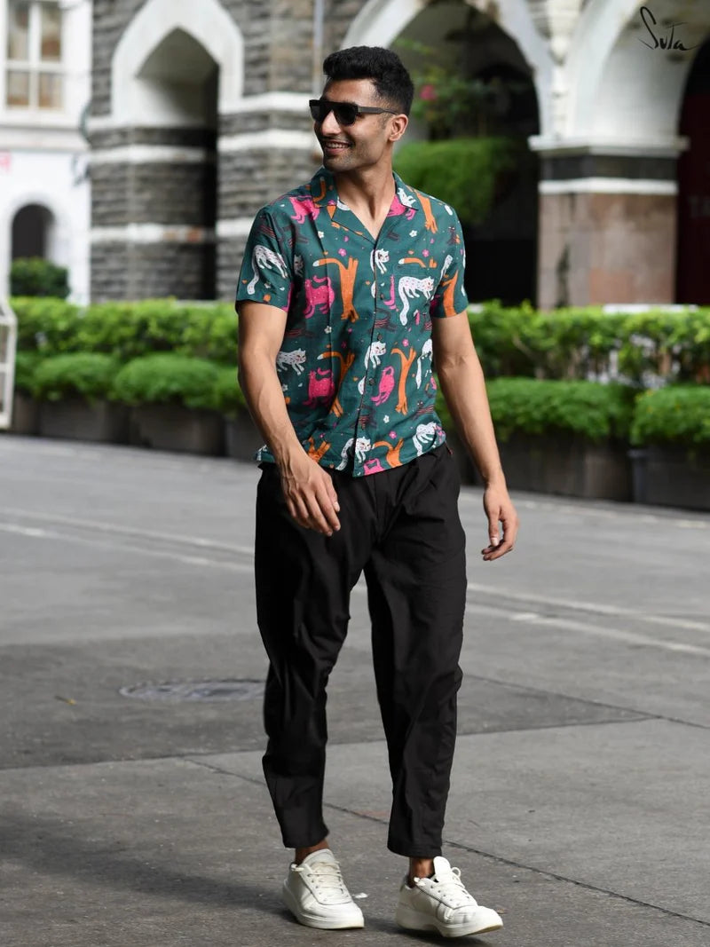 Man wearing a teal colorful patterned shirt on a street background