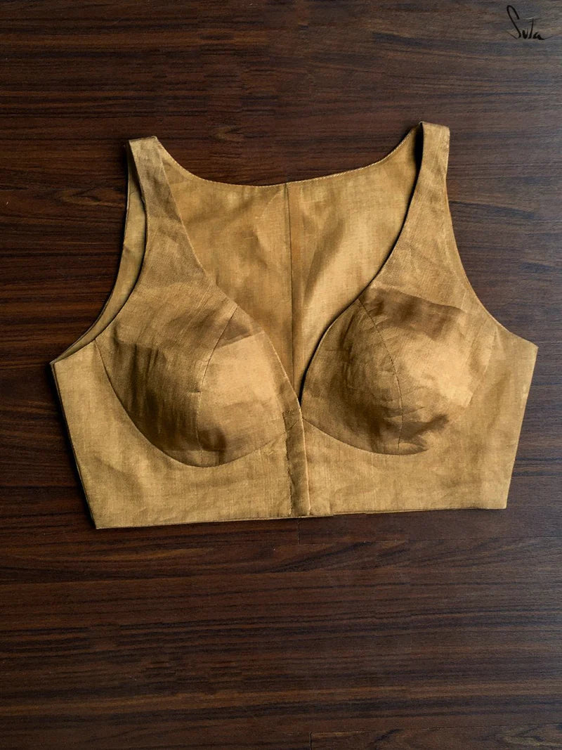 Gold sleeveless blouse on a wooden surface