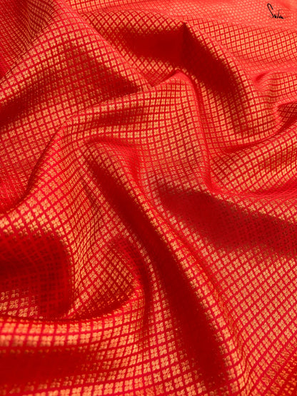 Close-up of red fabric with a subtle gold pattern