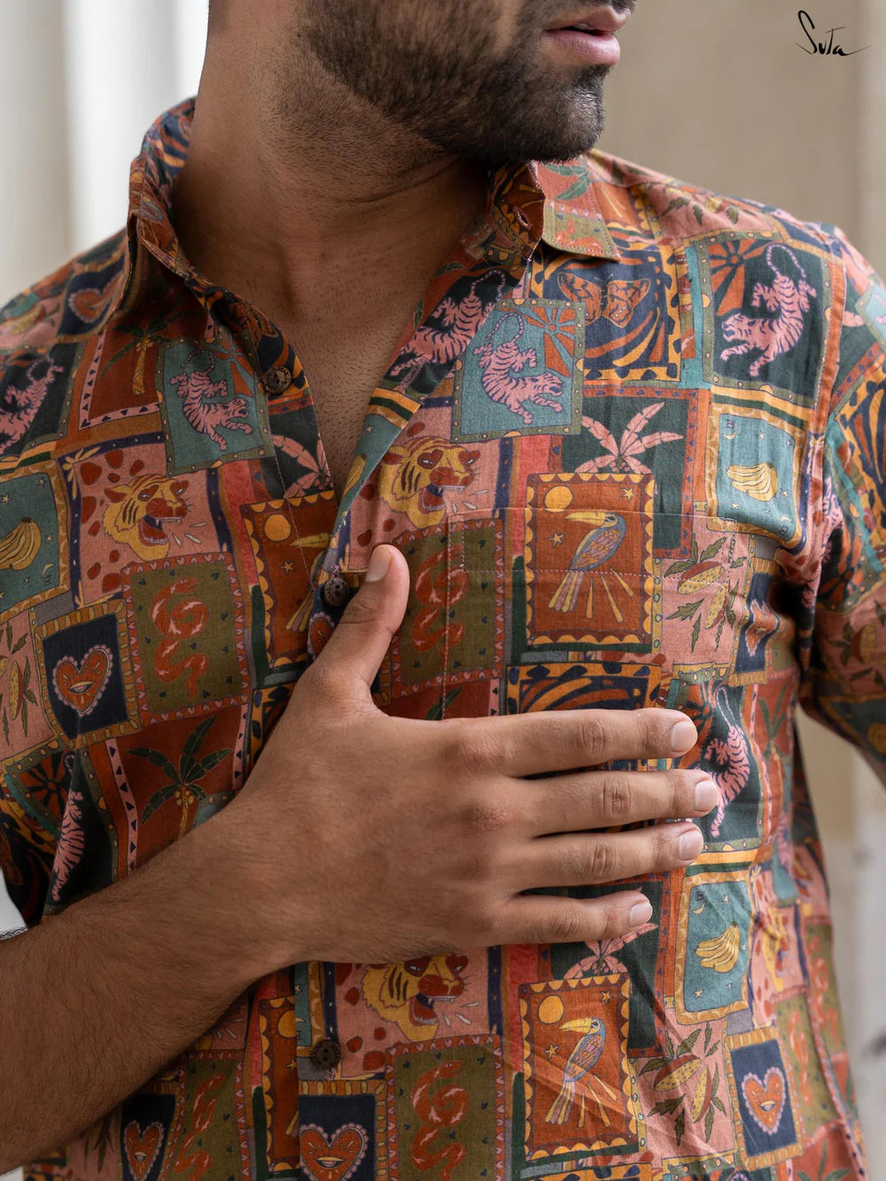 Person wearing a colorful patterned shirt with a neutral background