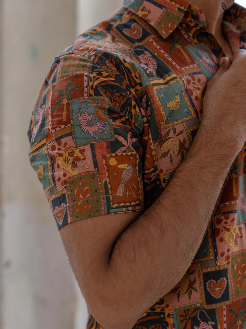 Close-up of a person wearing a colorful patterned shirt with a blurred background