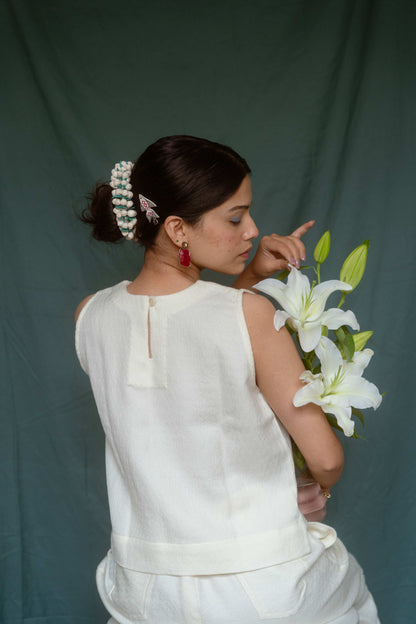 Woman holding a bouquet of white flowers against a plain background