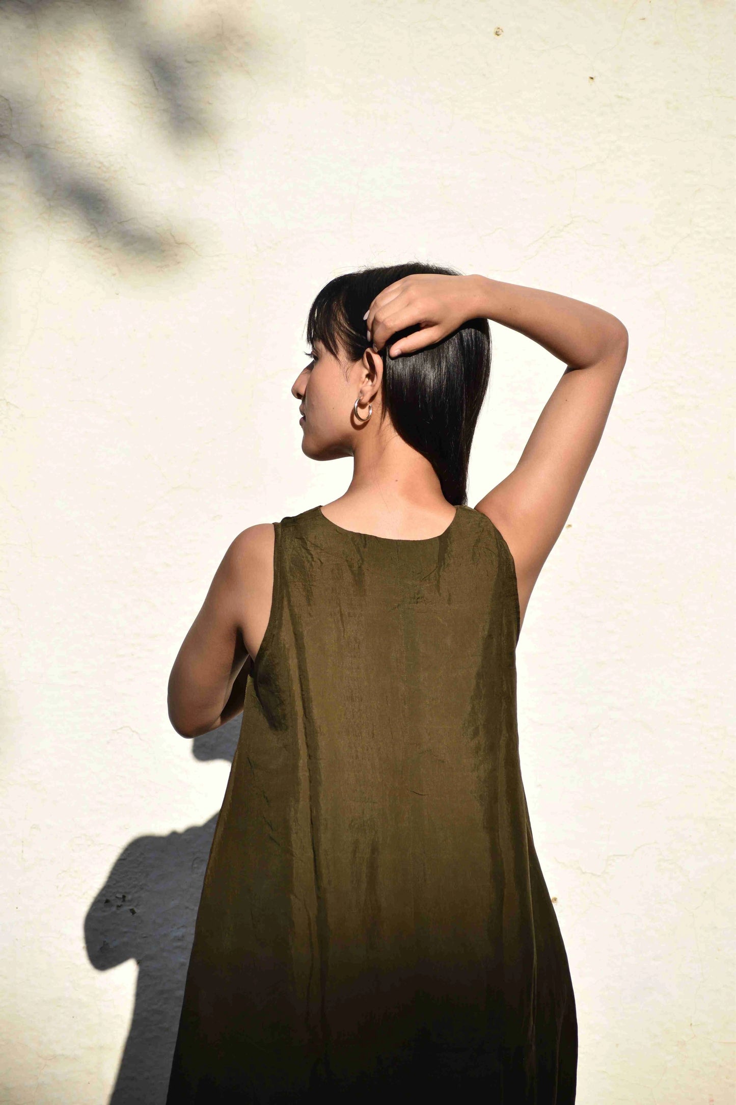 Woman wearing a green dress against a light background