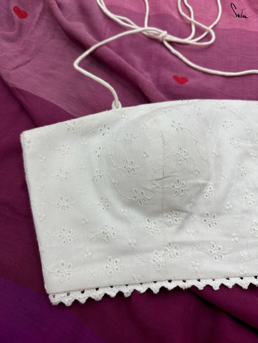 White eyelet halter blouse on a purple fabric background