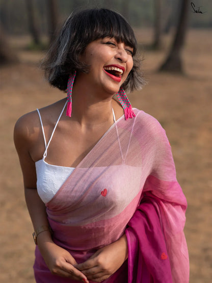 Woman in a white blouse and pink saree standing outdoors with trees in the background