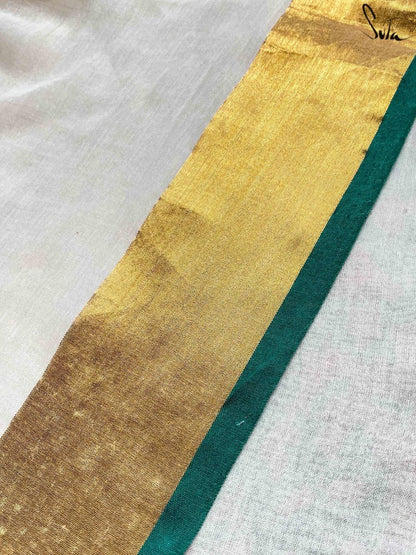 Close-up of a gold and green border fabric strip on a white saree