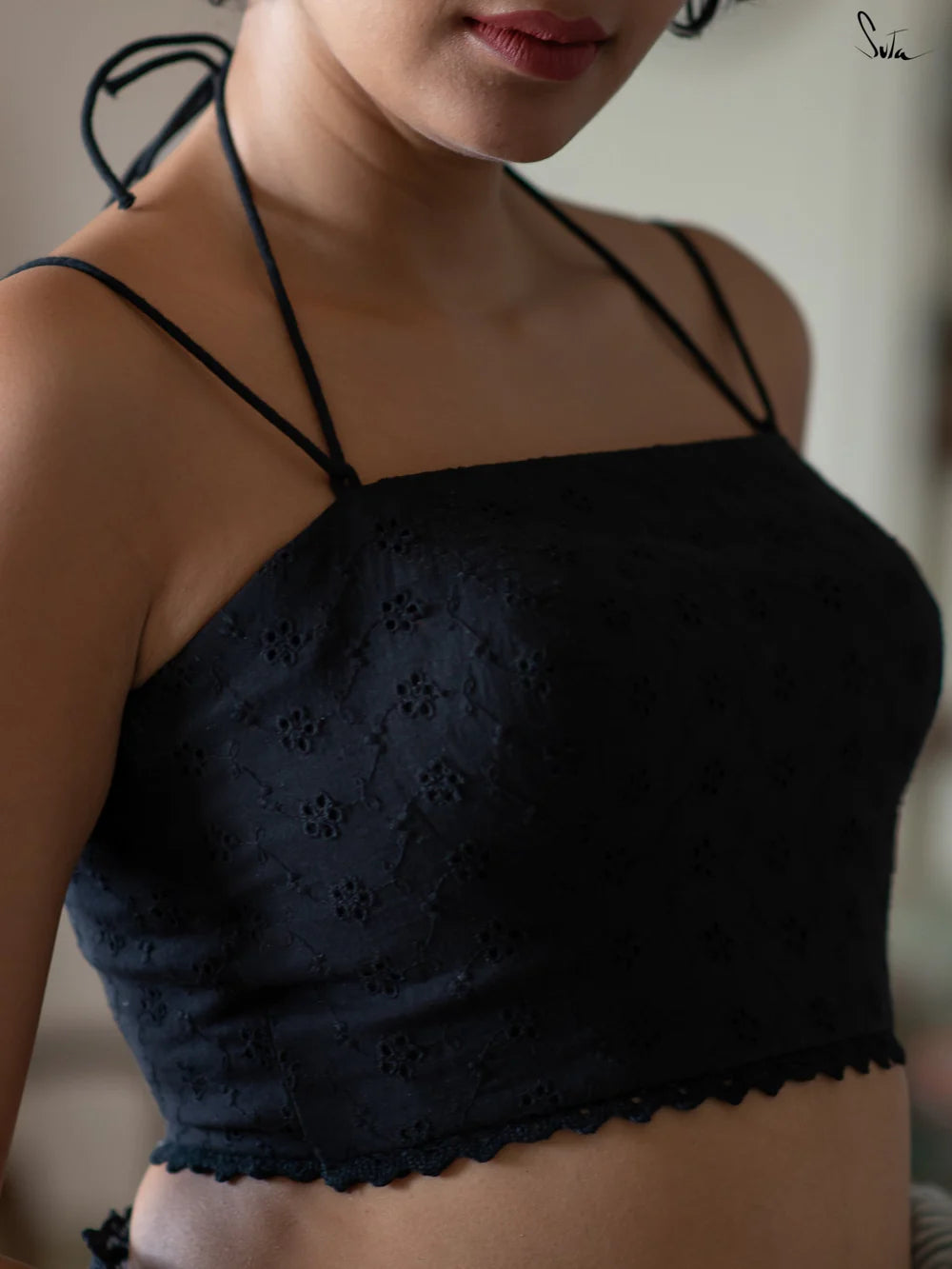 Black blouse worn by a person with a blurred background