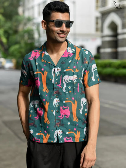 Man wearing a teal colorful patterned shirt on a street background