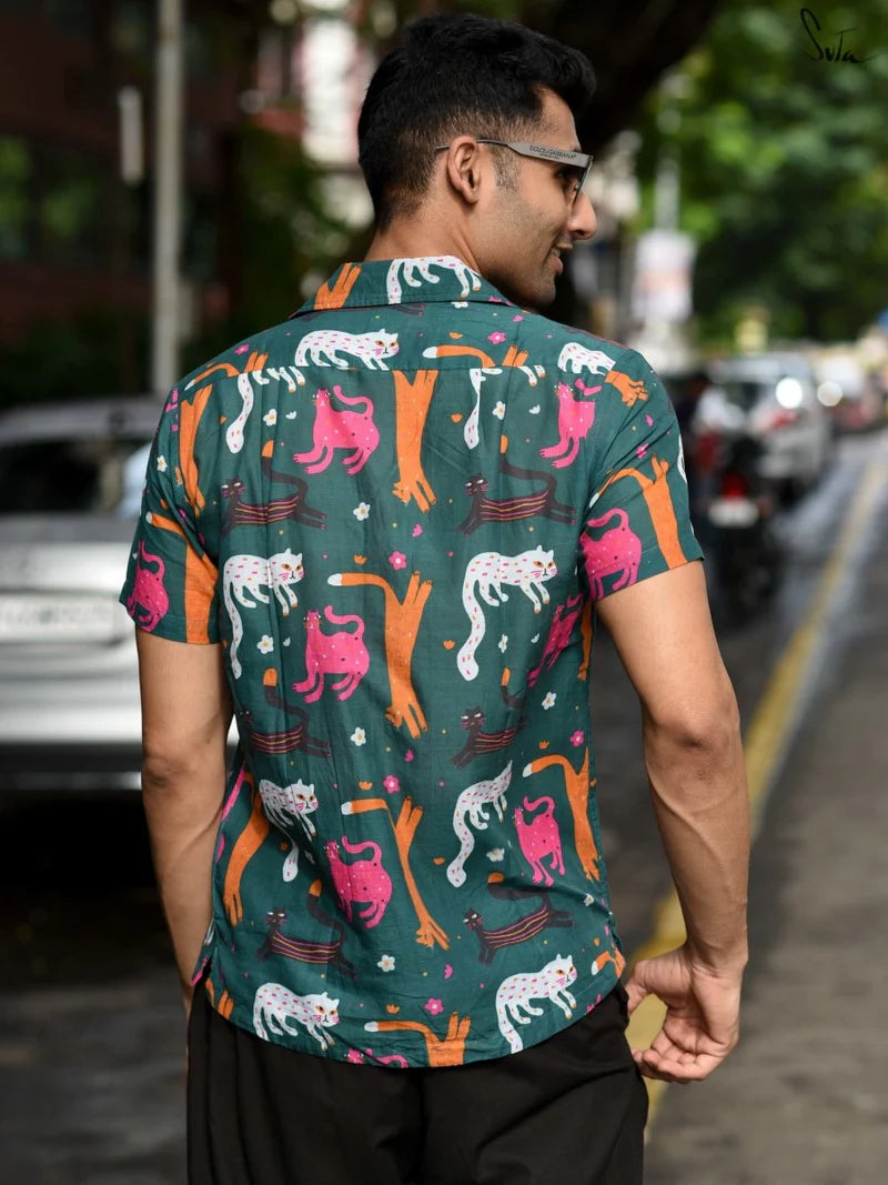 Man wearing a teal colorful patterned shirt on a street background