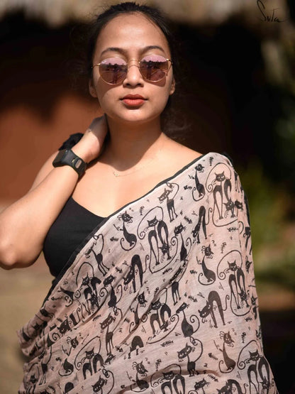 Woman wearing a patterned saree with a blurred natural background