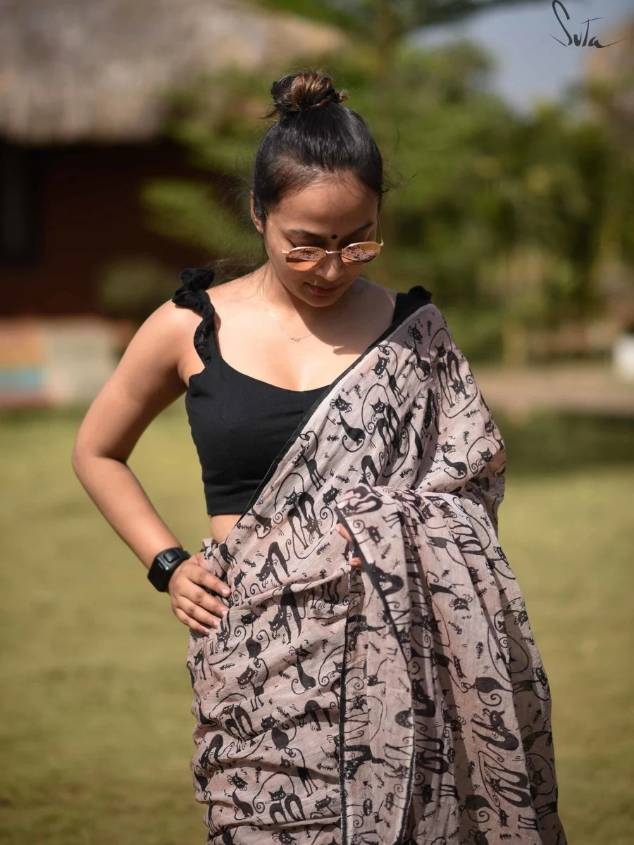 Woman wearing a black top and patterned saree outdoors
