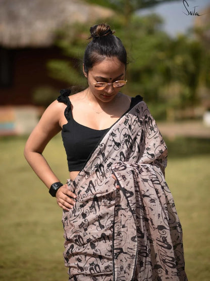 Woman wearing a black top and patterned saree outdoors