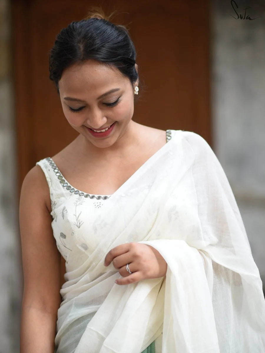 Woman wearing a white saree with a blurred background